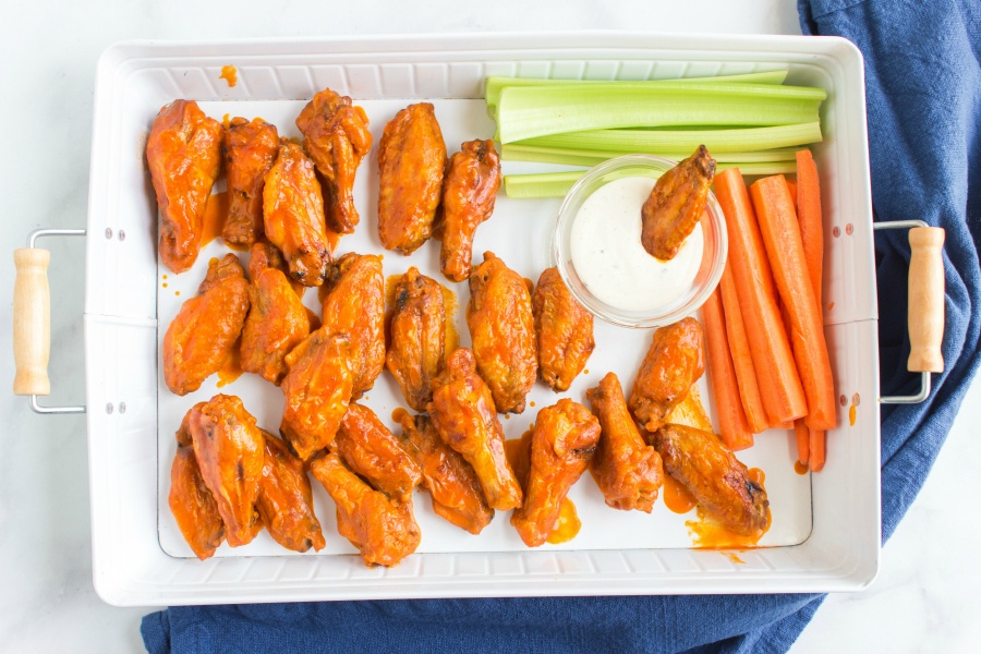  Buffalo chicken wings served on a platter with ranch dressing, carrots and celery