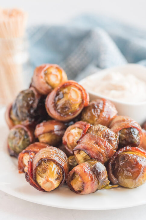 Bacon Wrapped Brussels Sprouts on a plate with sauce