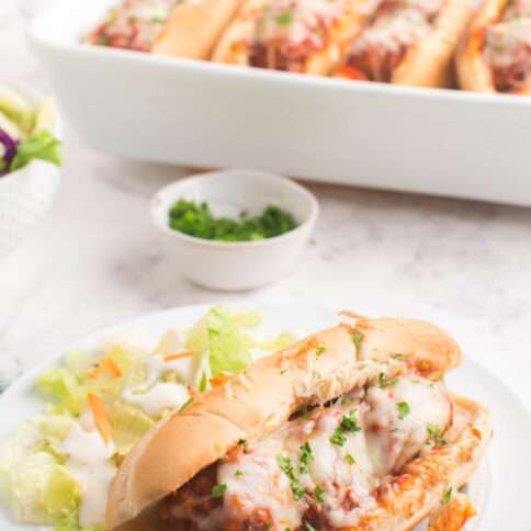 Baked Meatball Sub on a plate with a salad