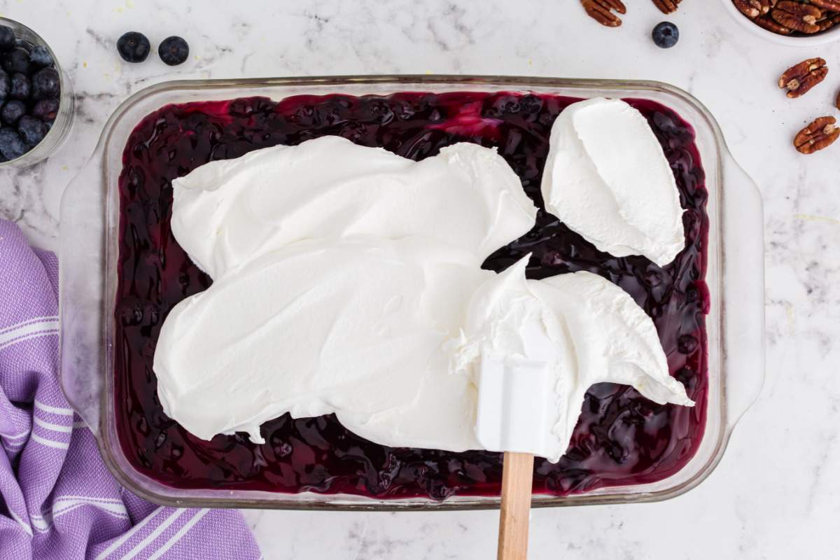 spreading whipped topping over pie filling