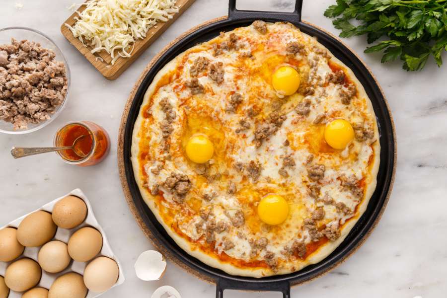 eggs cracked on top of pizza