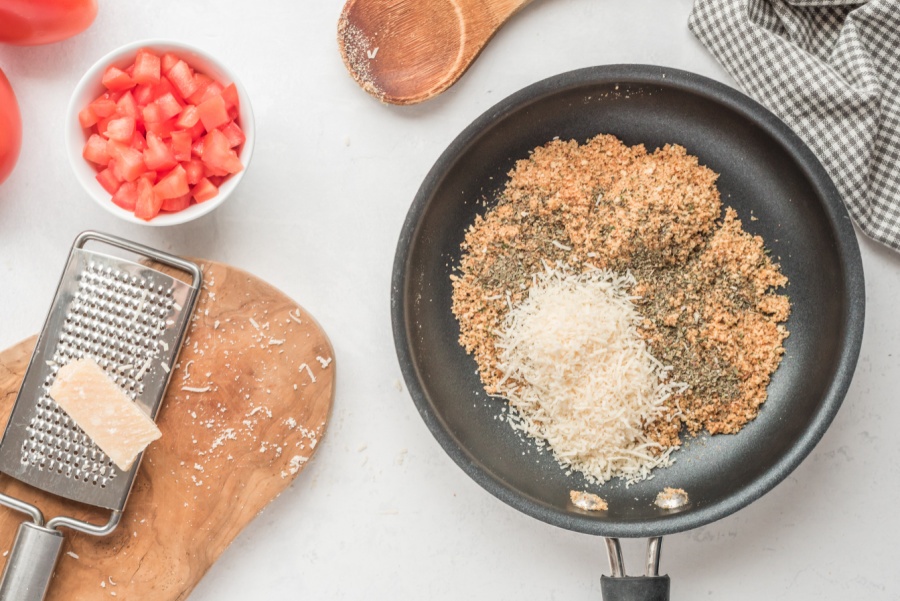 adding in cheese and basil to bread crumb mixture