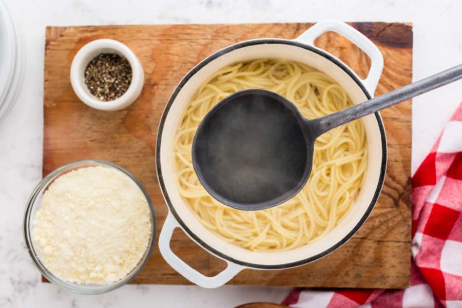 ladle scooping up pasta water from pot