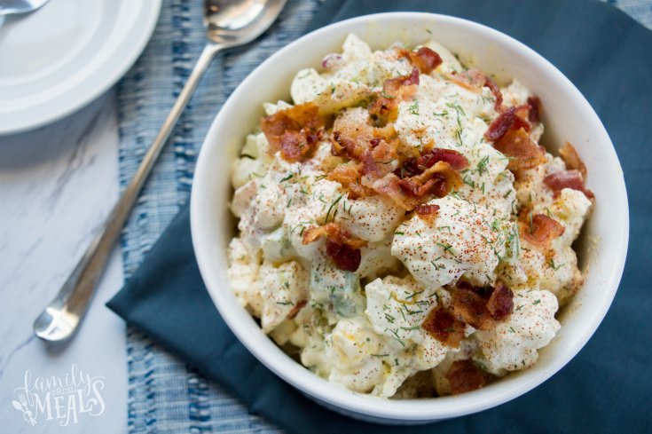 Cauliflower Potato Salad served in a white bowl and topped with bacon