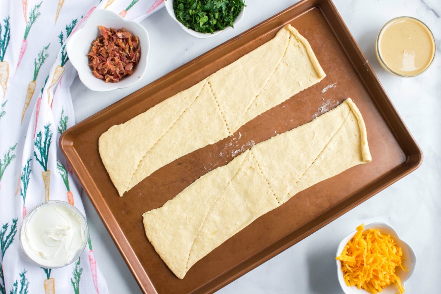 Rolling crescent roll dough on baking sheet