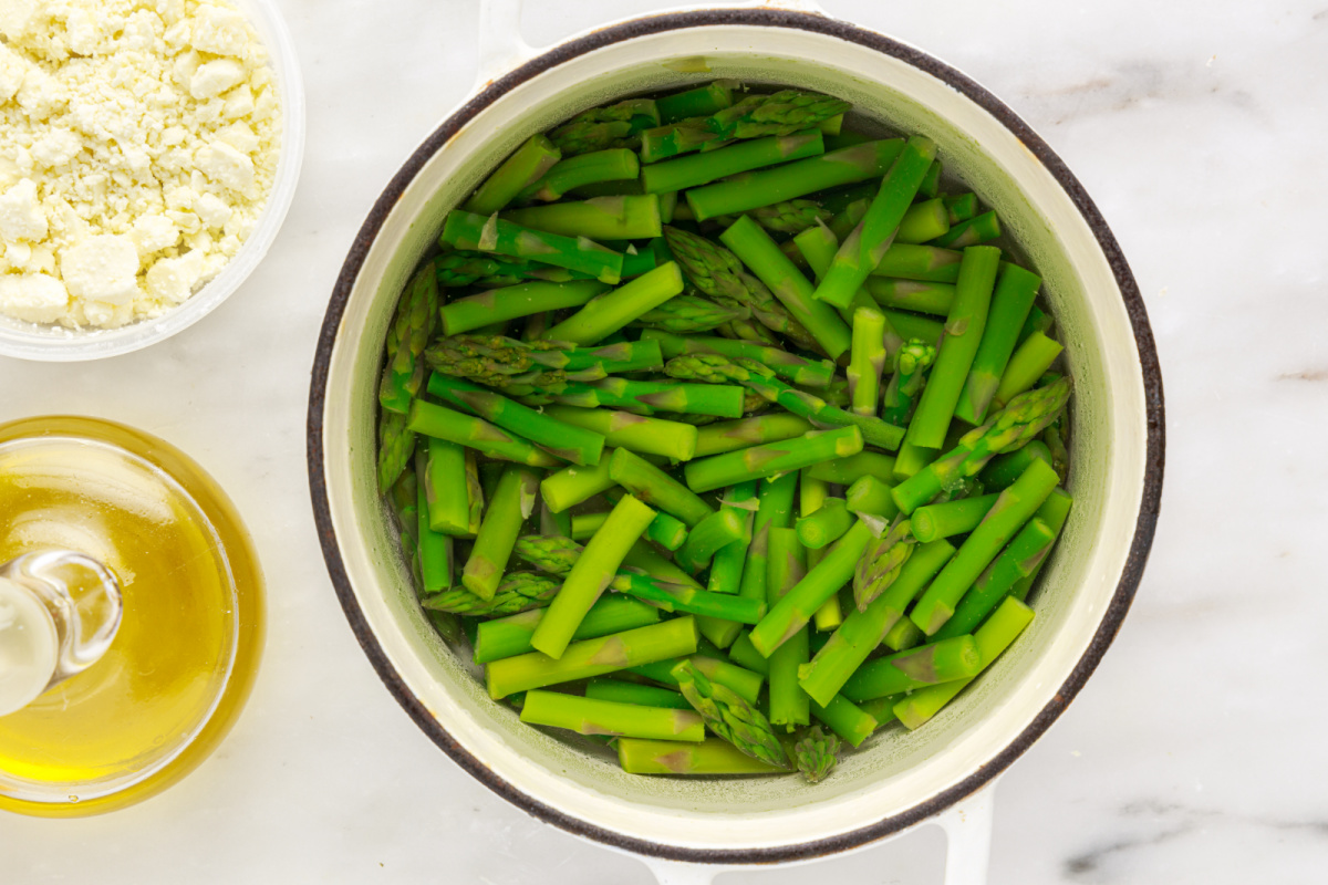 chopped asparagus in pot with water