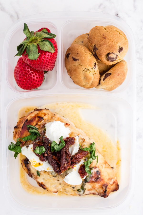 Copycat Carrabbas Chicken Bryan packed in a lunchbox with cookies and strawberries