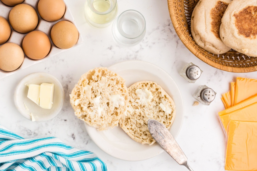 spreading butter on english muffins