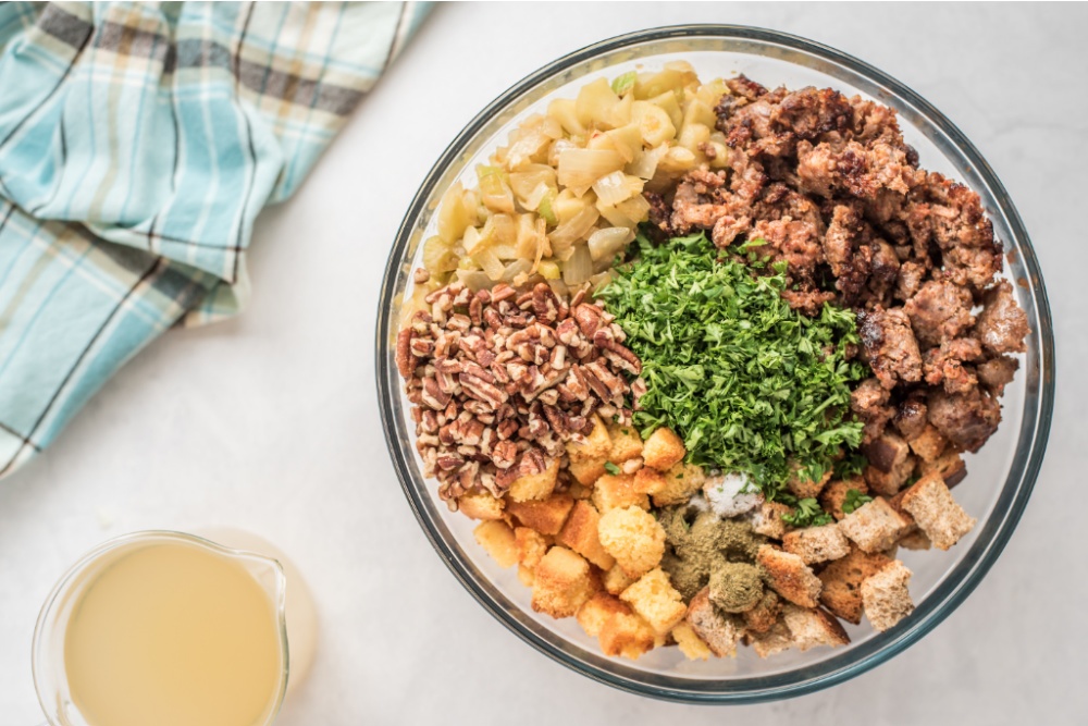 toasted cornbread and bread cubes, sausage, onion mixture, poultry seasoning, thyme, salt, and chopped parsley in a large mixing bowl