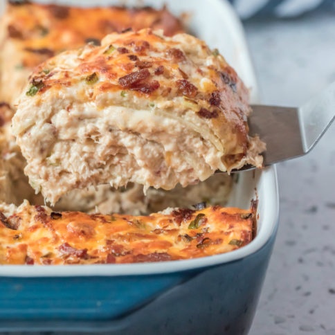 Scooping out a piece crack chicken lasagna with a spatula