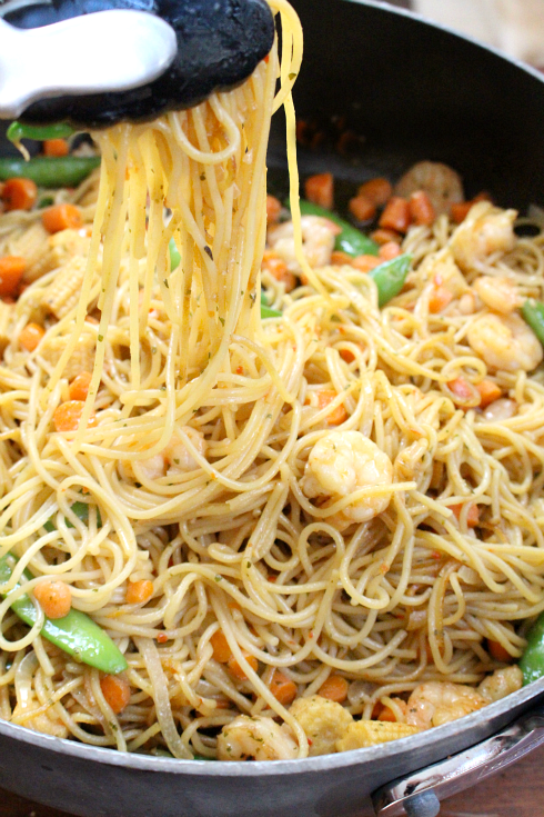 Honey Garlic Shrimp Lo Mein in a pan with tongs picking up some noodles