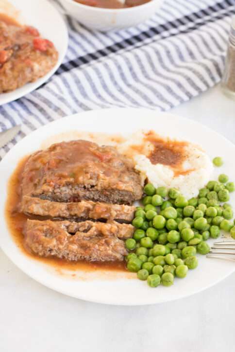 Crockpot Cubed Steak on a plate with peas and potatoes