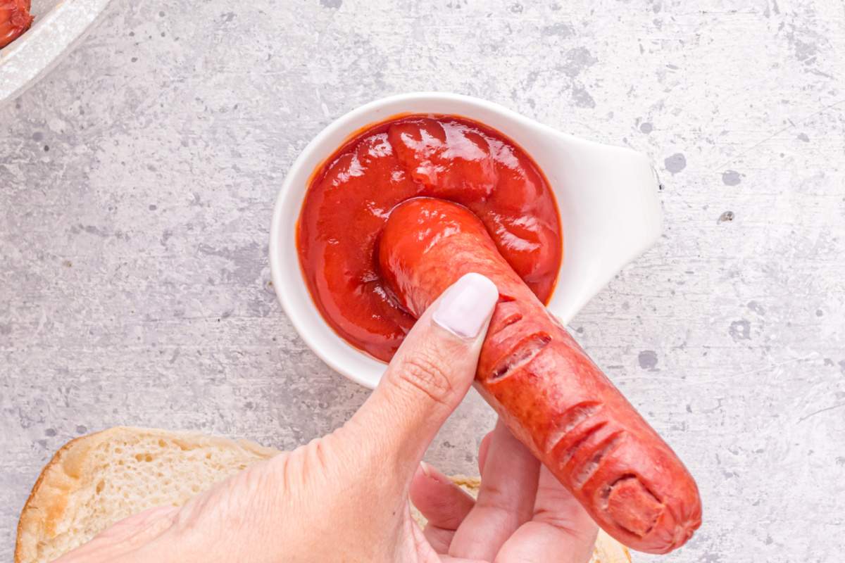 dipping hot dog in ketchup