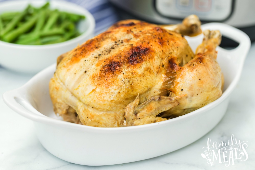 Instant Pot Dill Pickle Chicken Recipe - Cooked whole chicken in white baking dish