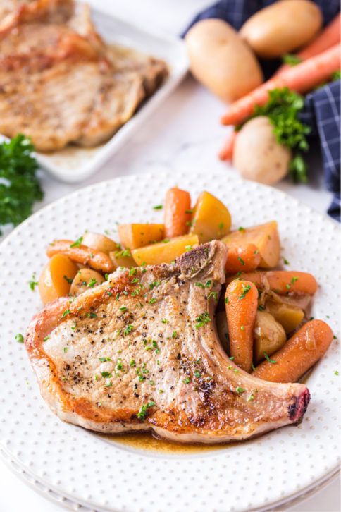 Instant Pot Pork Chops with potatoes and Carrots - served on a white plate