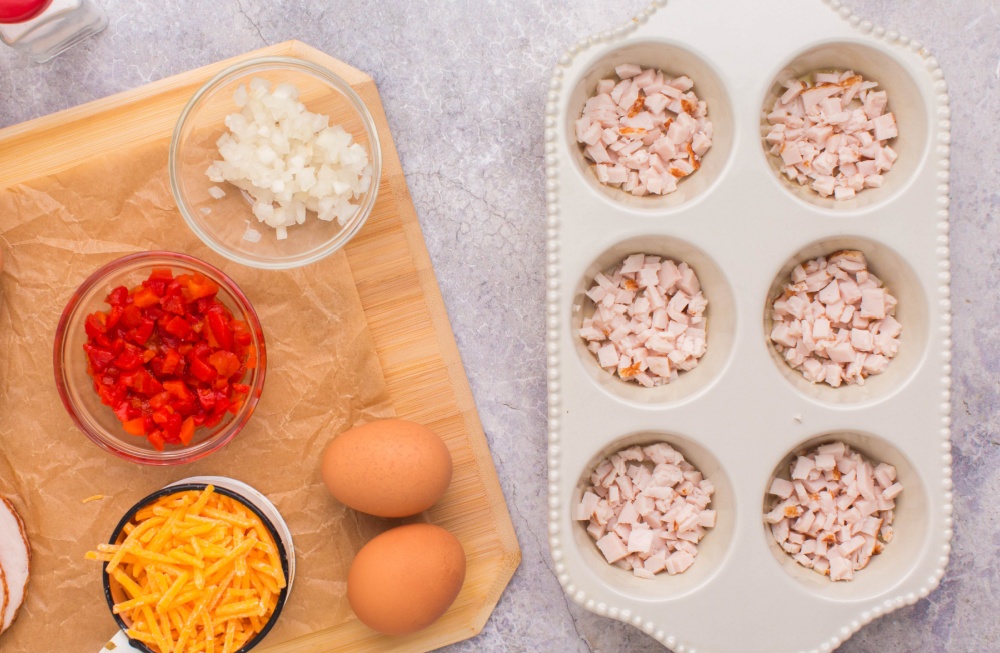 chopping turkey placed in muffin tin, with other ingredients on cutting board