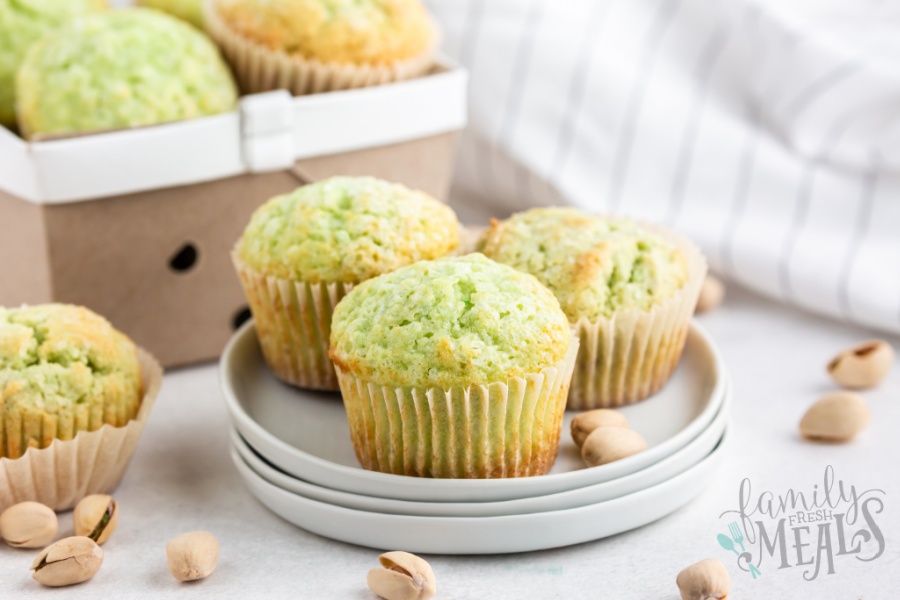 three cooked muffin on a stack of white plates