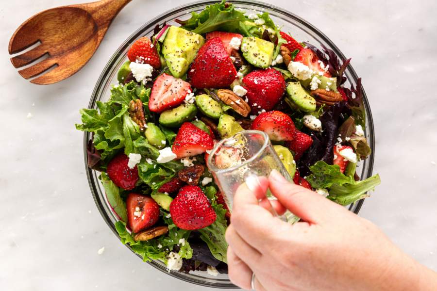 pouring dressing over salad