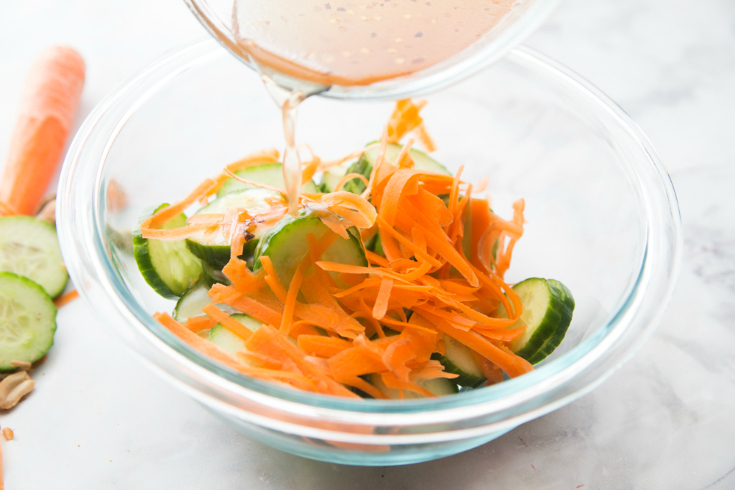 Thai Cucumber Salad - cucumber slices, carrot shreds, in a glass bowl with sauce