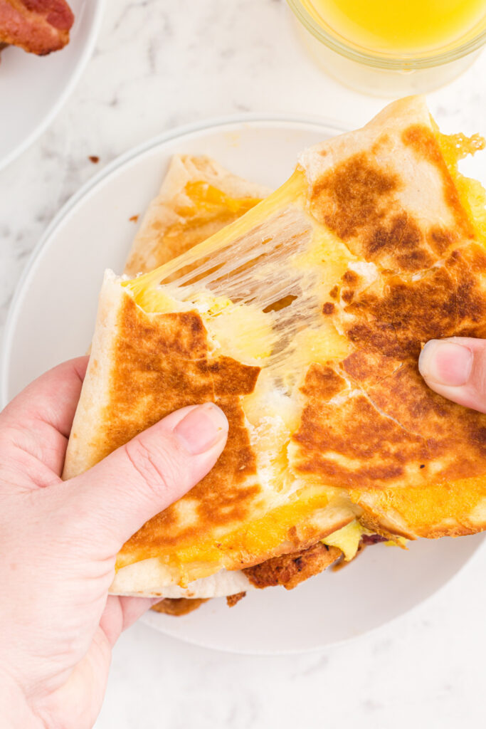 hand pulling apart breakfast quesadilla