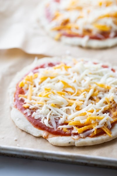 personal size cheese pizza on parchment paper