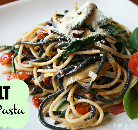 BLT Pasta served on a white plate, topped with parmesan cheese